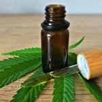 Person using medical cannabis oil for anxiety and pain relief, highlighting the health benefits of marijuana in 2025.