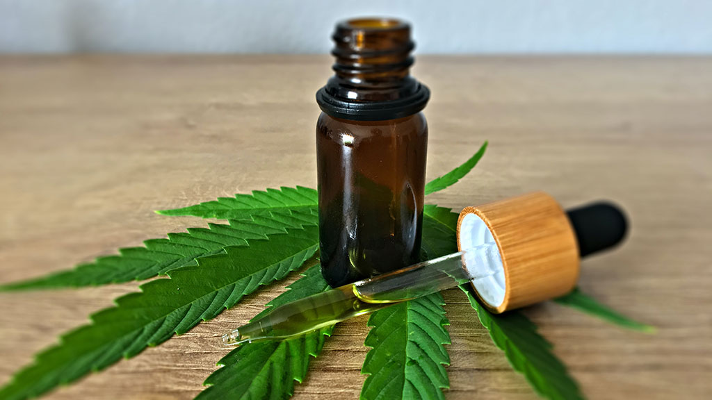Person using medical cannabis oil for anxiety and pain relief, highlighting the health benefits of marijuana in 2025.